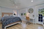 First floor primary bedroom with queen size bed and work station